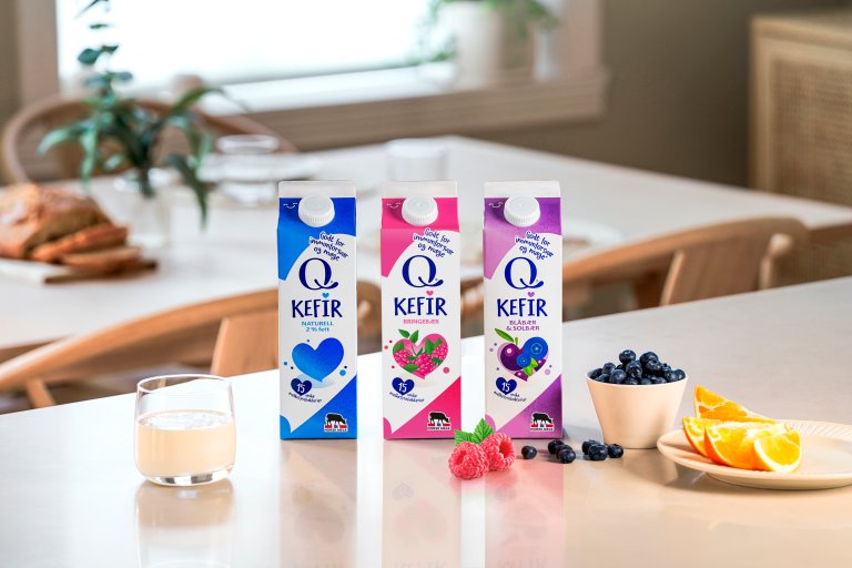 Alle Q Kefir produktene oppstilt på et bord med smakene Naturell, Bringebær og Blåbær & Solbær